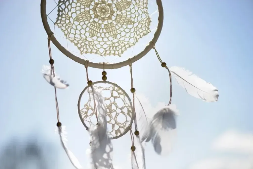 蓝天背景下的白色捕梦网,象征着过滤噩梦并捕捉潜意识中的吉凶信息