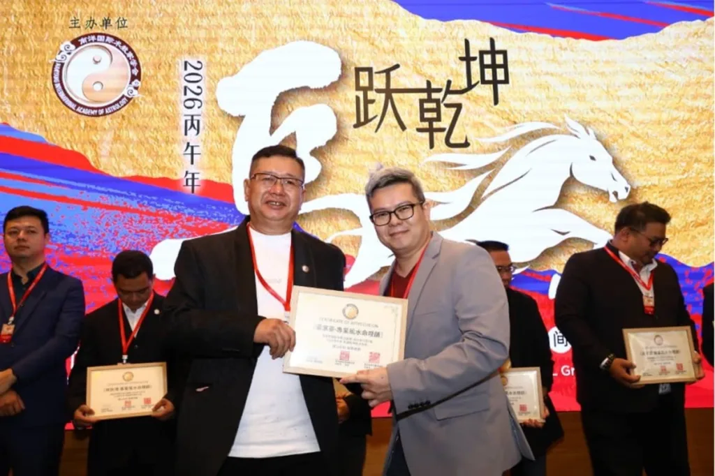 猫哥（LuckyCatFengShui）在“2026丙午年跃乾坤”背景板前获颁专业风水命理师证书，手持奖状