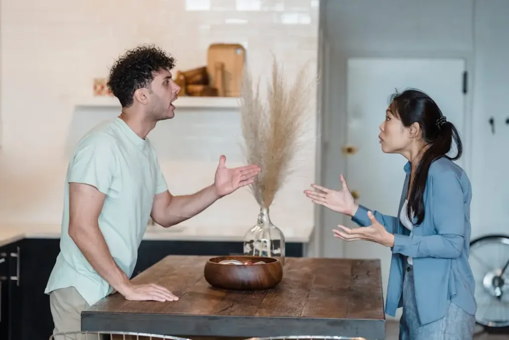 A couple having a heated argument in their kitchen. In Feng Shui, frequent arguments are often a sign of unbalanced Five Elements (such as excess Fire energy) or stagnant Qi. This illustrates how a poor environment can negatively impact relationships and mental health.