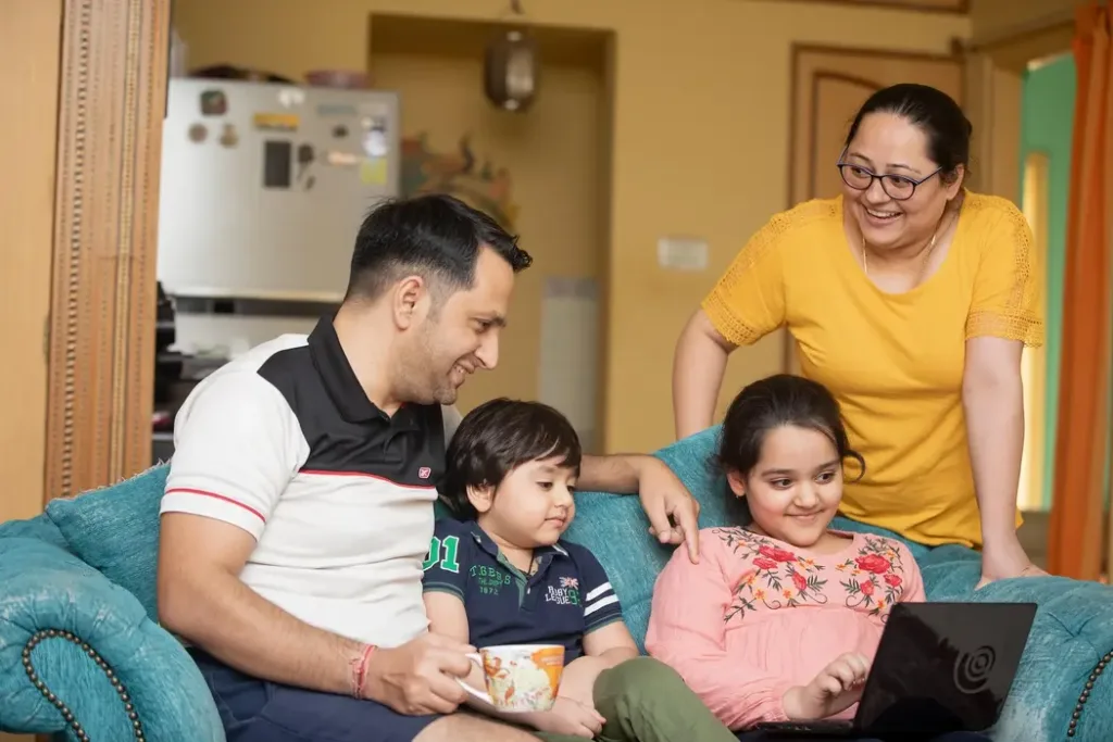 Family Harmony is the Luckiest Thing - 猫哥风水|马来西亚风水・紫微斗数・奇门遁甲 A happy family sitting together on a sofa, representing domestic harmony and good Feng Shui energy.
