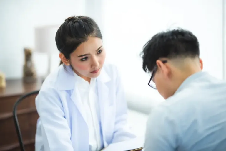 一位医生正在专注地为患者进行问诊和记录，象征着专业的风水师在进行堪舆时，需要像良医一样综合运用多种理论进行精准诊断，而非生搬硬套单一门派。